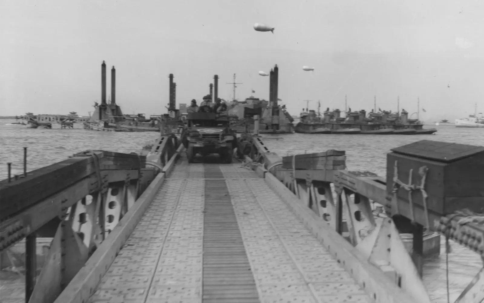 Véhicules de l’armée américaine empruntant une chaussée flottante de Mulberry A au large d’Omaha Beach le 16 juin 1944